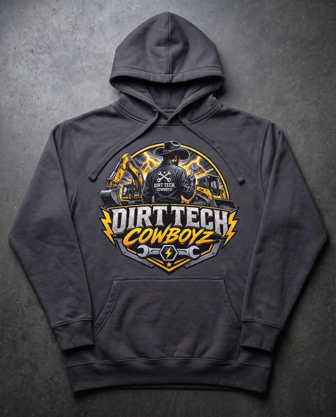 Charcoal grey Dirt Tech Cowboyz pullover hoodie laid flat on dark concrete.