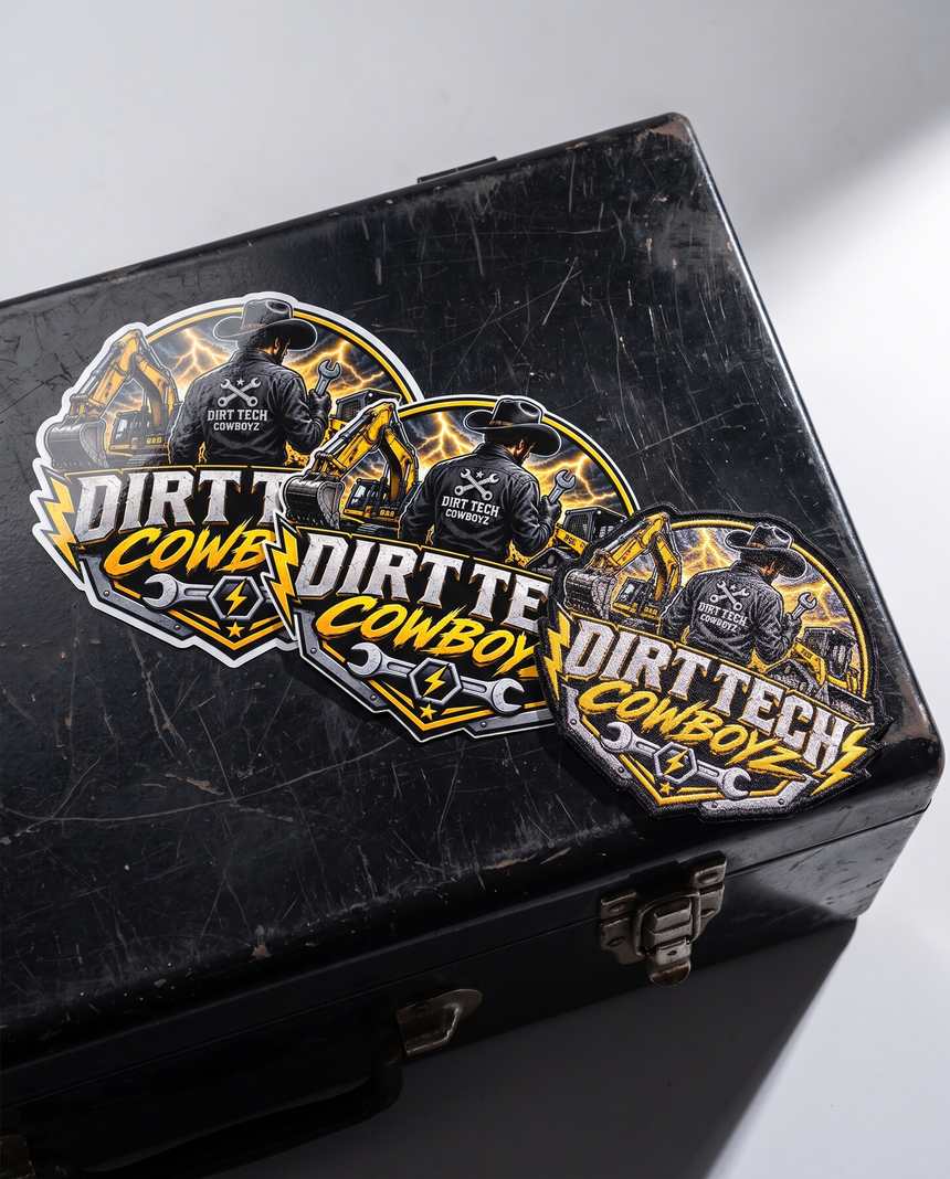 Dirt Tech Cowboyz die cut vinyl stickers and an embroidered patch on a black toolbox lid.